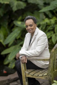 Lori Lightfoot headshot, sitting on a bench