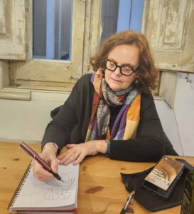 Portrait of speaker Tarna Klitzner drawing on a notepad with a window behind her.