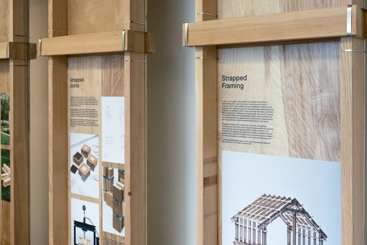 Detail of the exhibit showing temporary wooden walls displaying text panels and images.