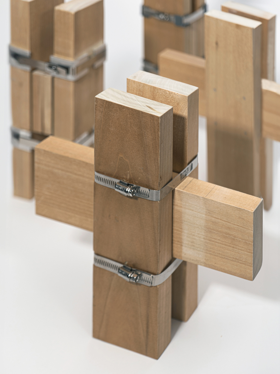 Detail of a right angle join using three blocks of wood and steel straps.