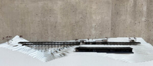 Model of a long brown building on top of rice terraced landscape made from styrofoam