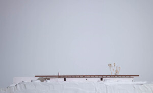 A white model of terraced terrain with a building in the middle