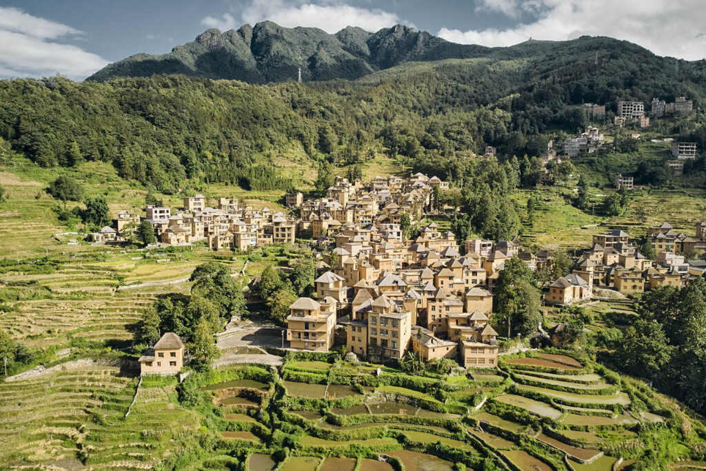 A village on a mountain slope with rice terraces in the foreground