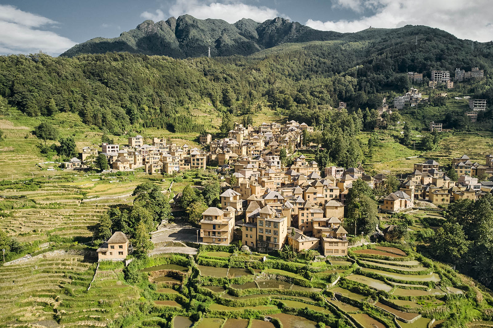 A village on a mountain slope with rice terraces in the foreground