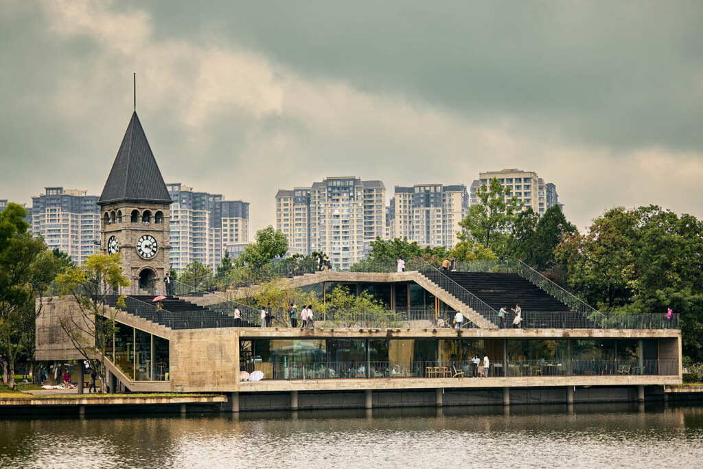 A building with a clock tower on the left surrounded by water