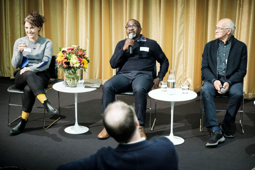 Three people speak on a panel at the Harvard Graduate School of Design.