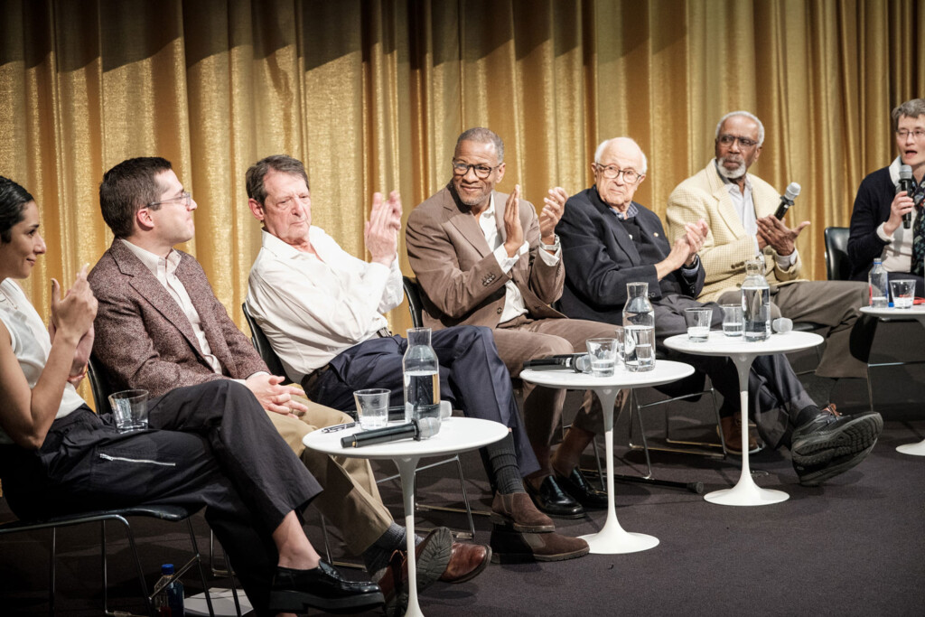 Seven people participate in a panel discussion in Piper Auditorium.