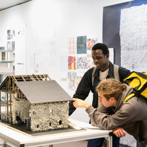 Two people viewing an architectural model in Druker Design Gallery.