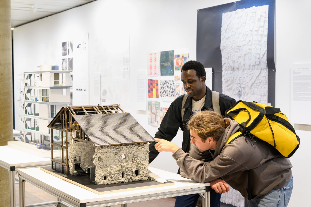 Two people viewing an architectural model in Druker Design Gallery.
