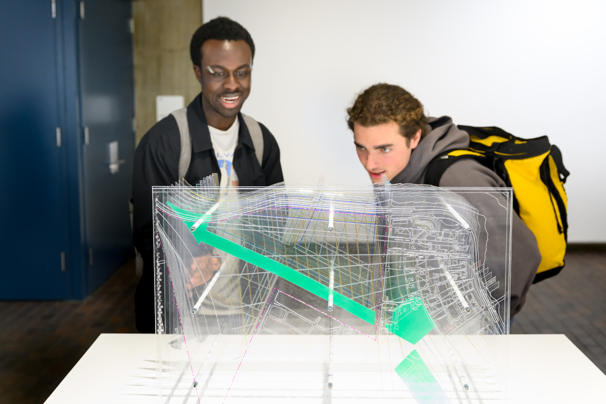 Two people viewing a model made of layers of acrylic.
