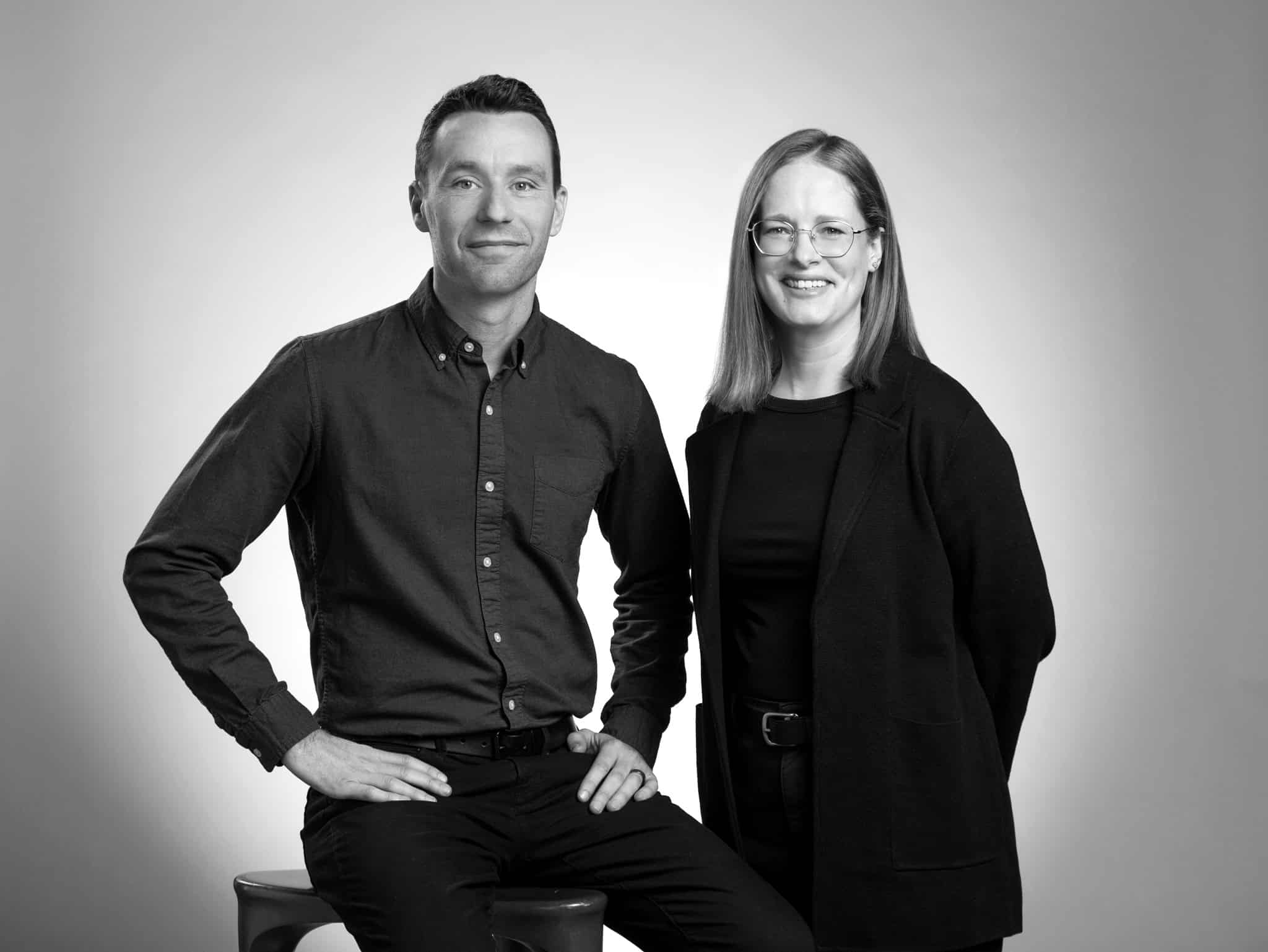 Chris Merritt and Nina Chase post next to each other. B&W photograph.