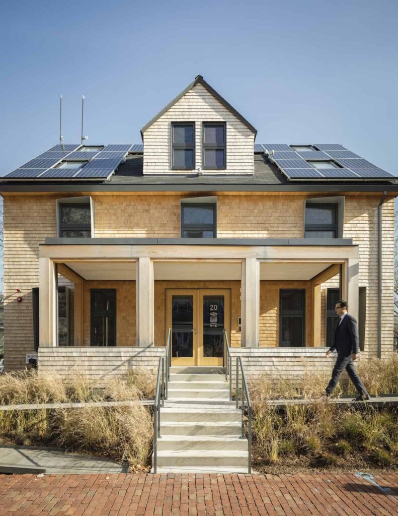 A man walks in front of the Center for Green Cities and Buildings house.