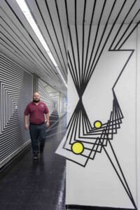 Gund Hall staff member walks in optical illusion installation