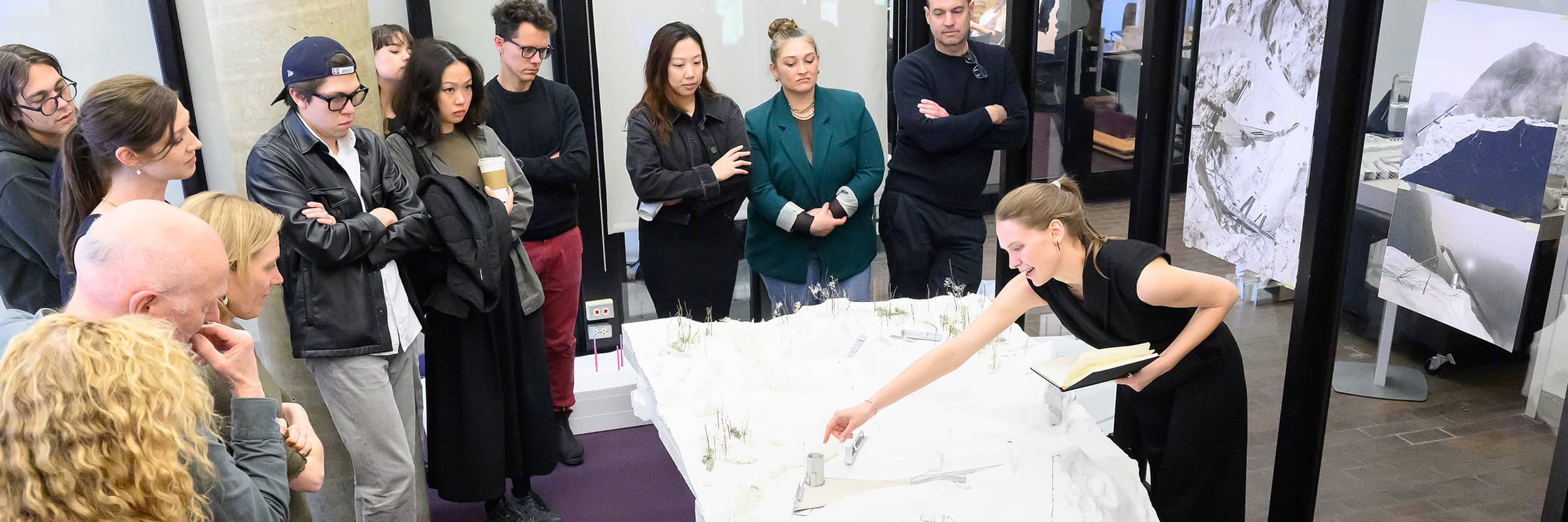 Student explaining a model to a group during a review.