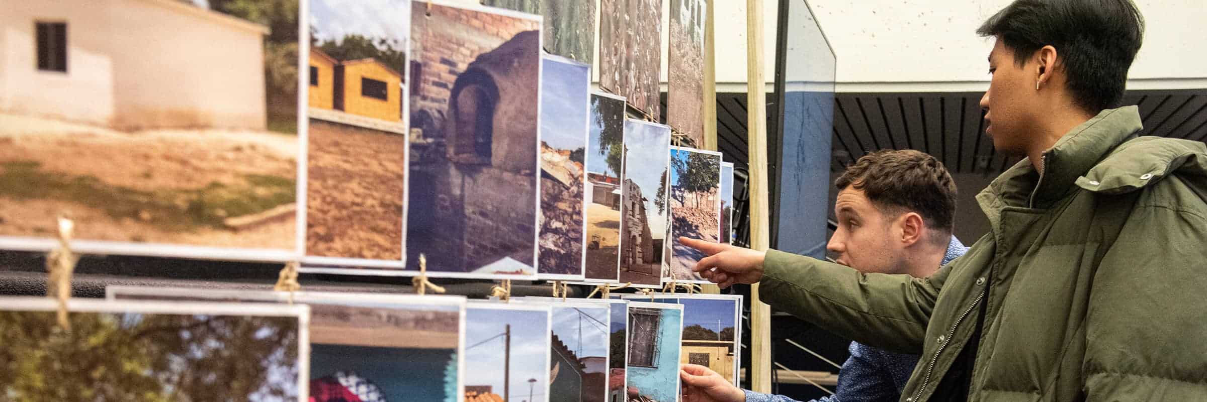 Students examining handing photos in an exhibition.
