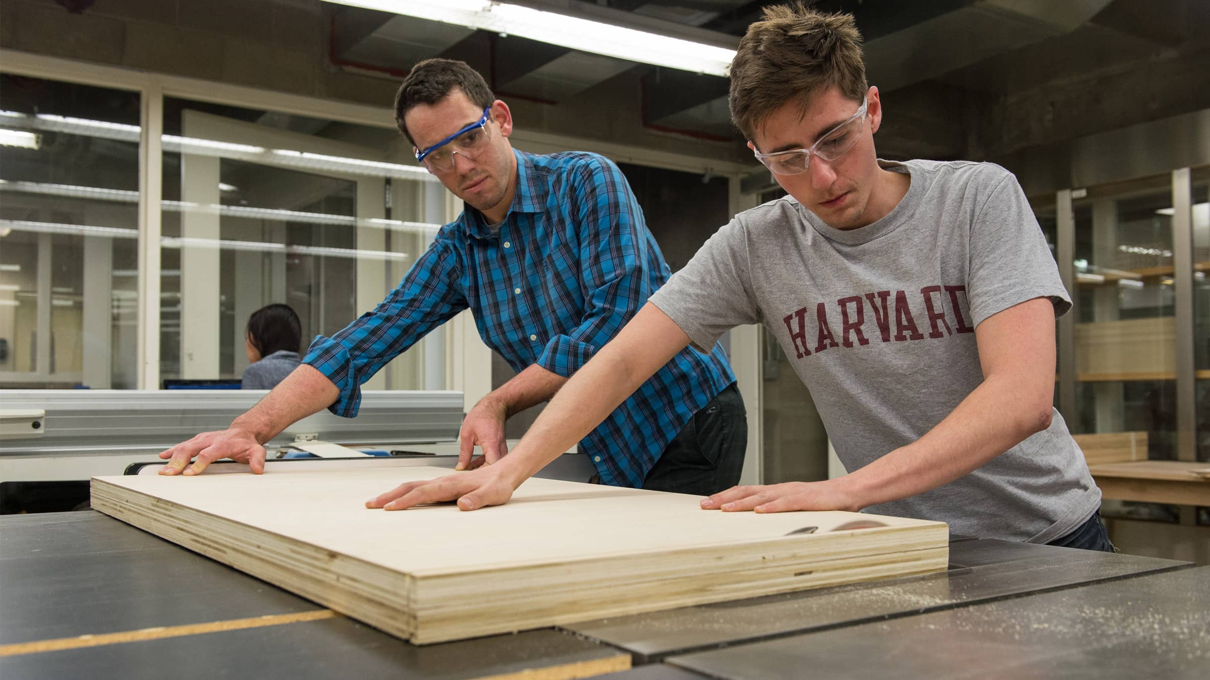 Students in the Fab Lab working together to cut a piece of wood.