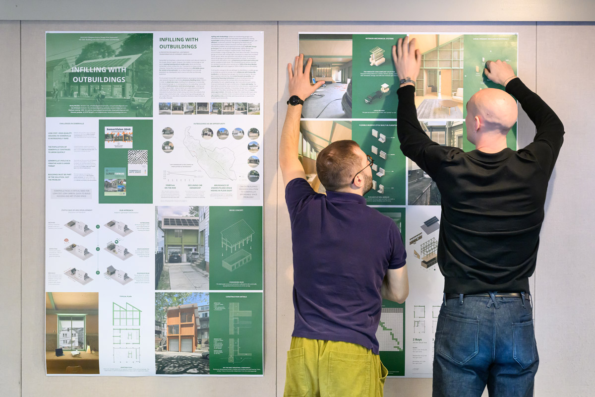 Students working together to hang posters for an exhibition.