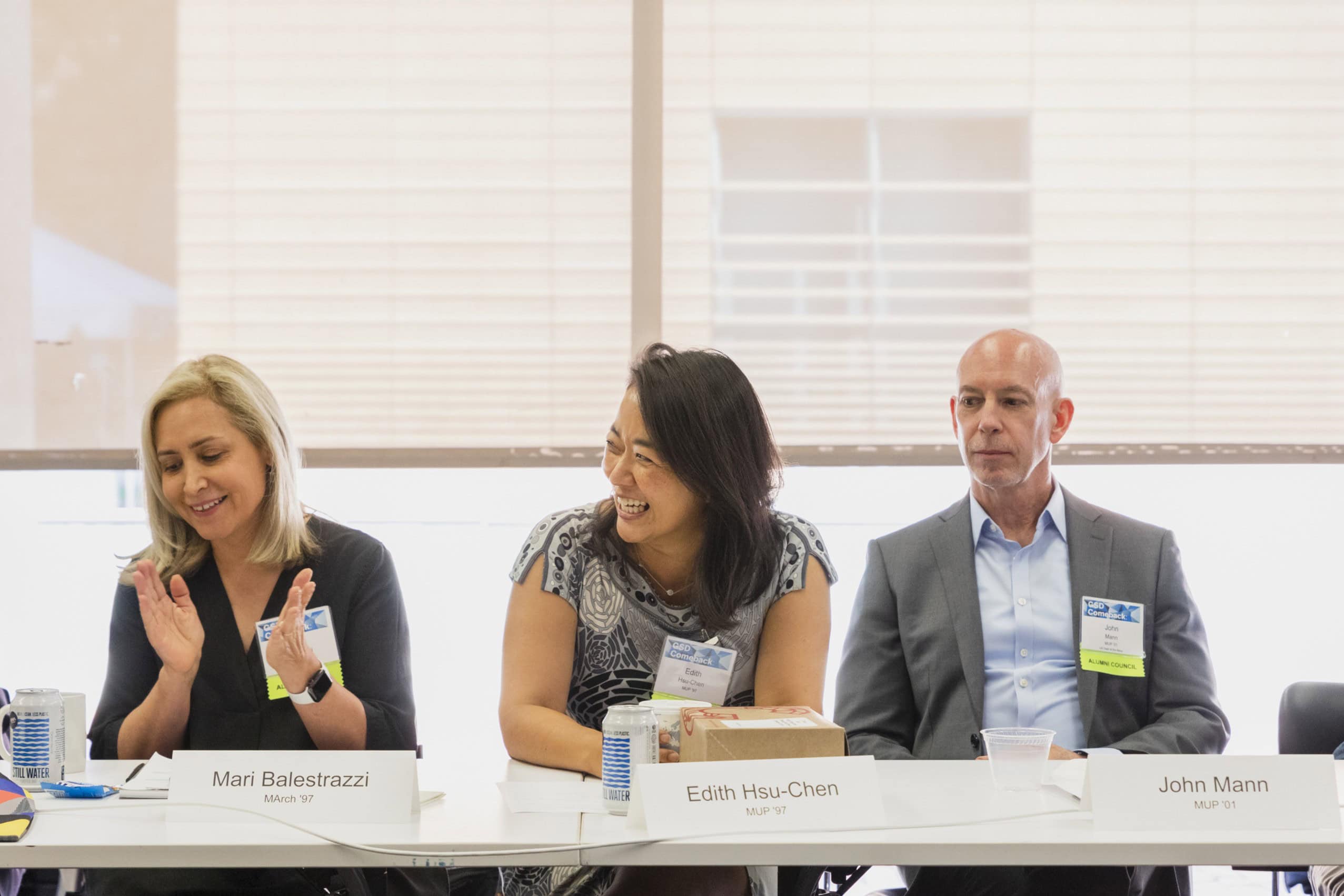 Three Alumni Council members sit around a table smiling