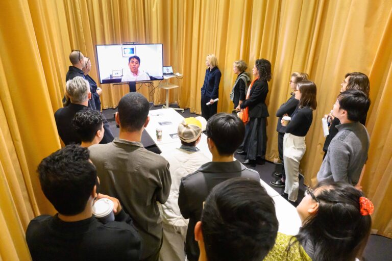 Students and faculty of studio review gathered around tv to watch donor remarks