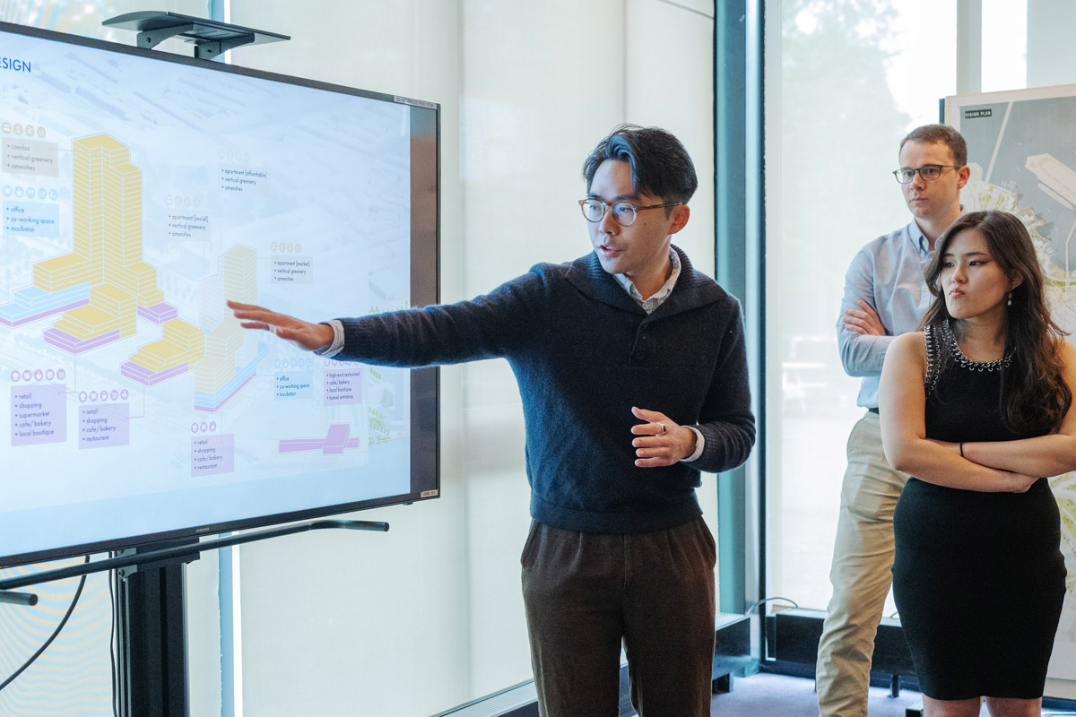 Student standing before a presentation and pointing during a review.