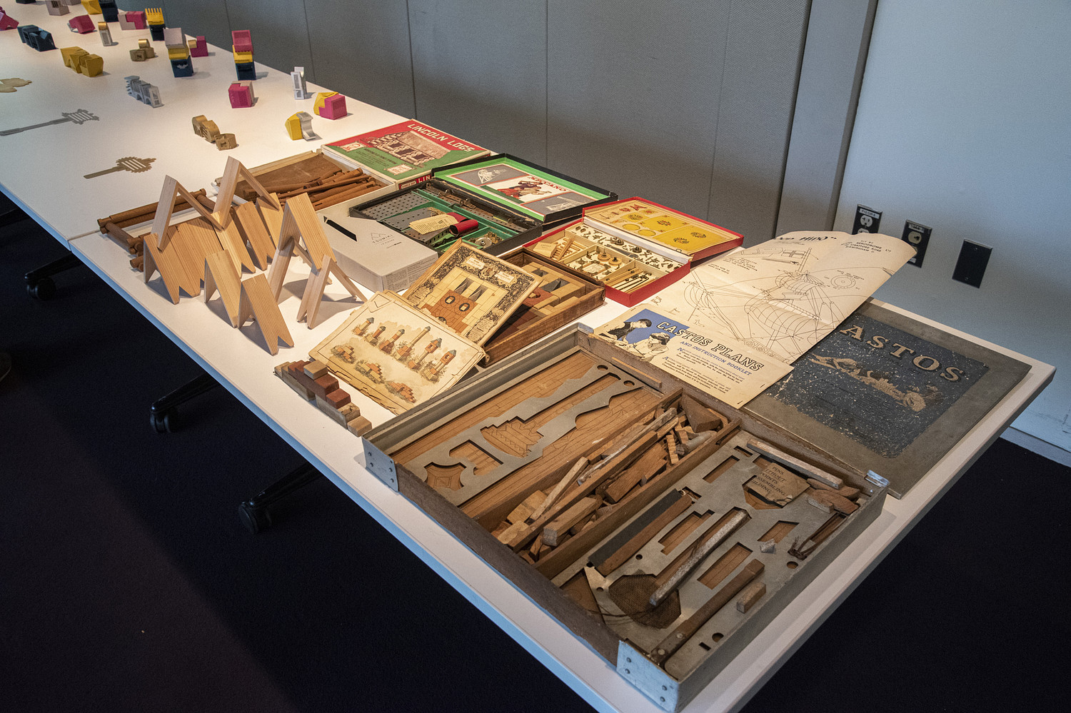 A white table displaying a series of wooden and metal objects.