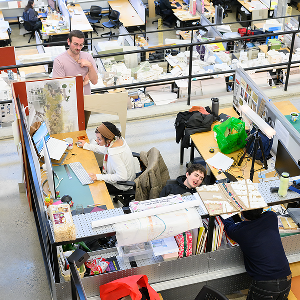 Aerial view of desks with various students and other people milling about.