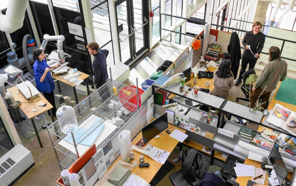 Students work in the Gund Hall trays, surrounded by projects and making tools.
