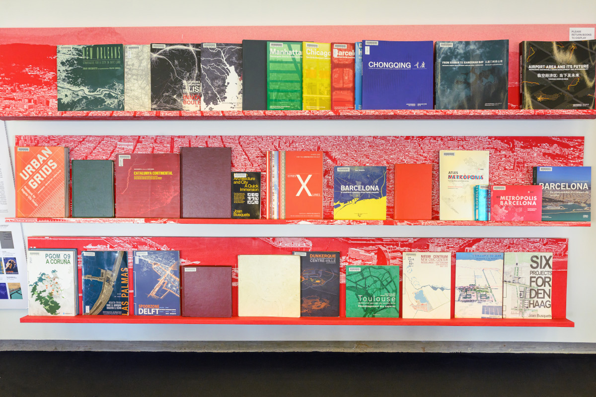 Red bookshelves displaying a variety of colorful books.