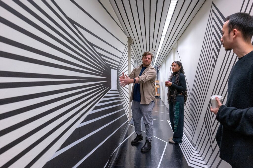 people talk in the hallway about the black and white optical illusions made by students