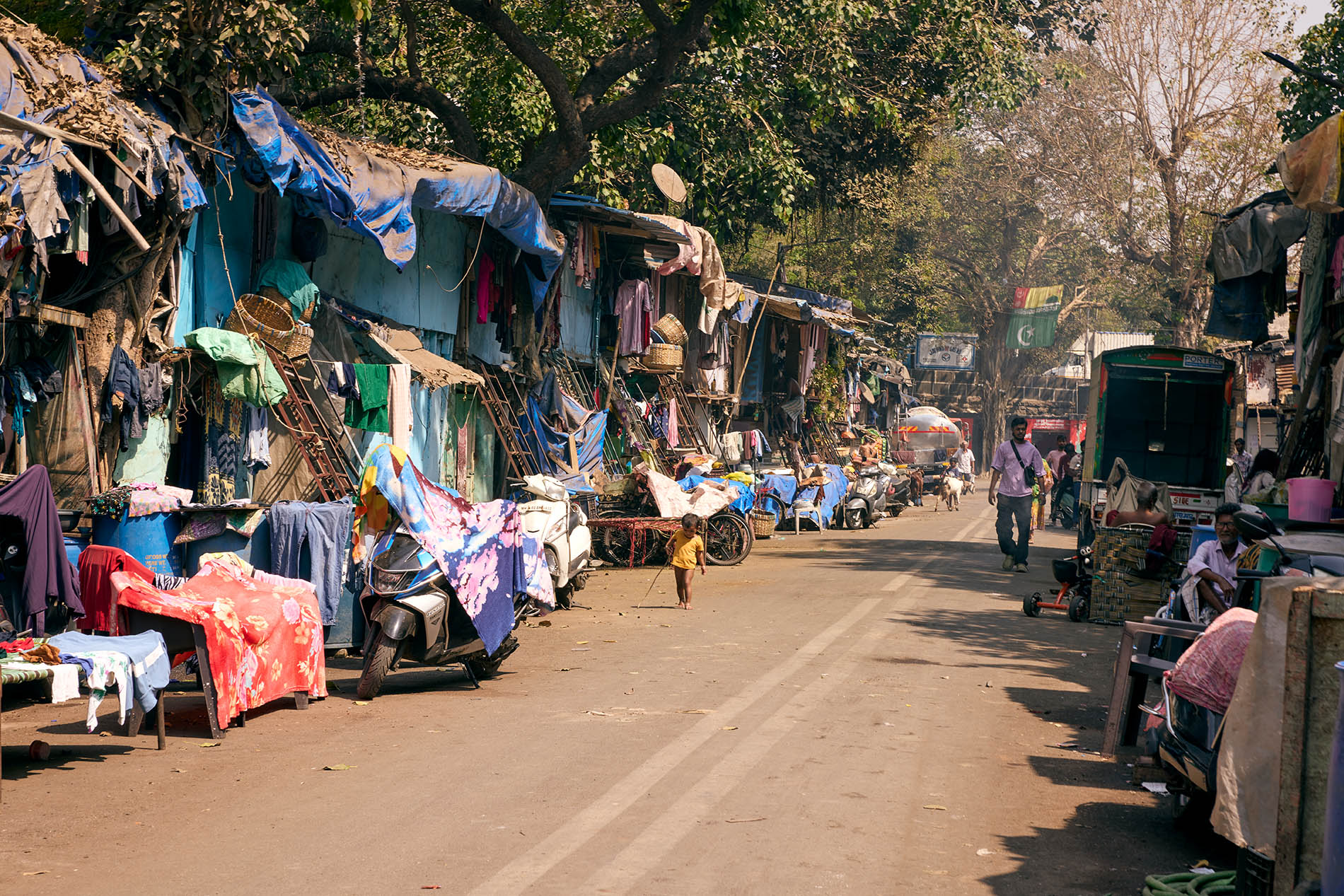 Informal houses along a street with people doing daily chores in Mumbai