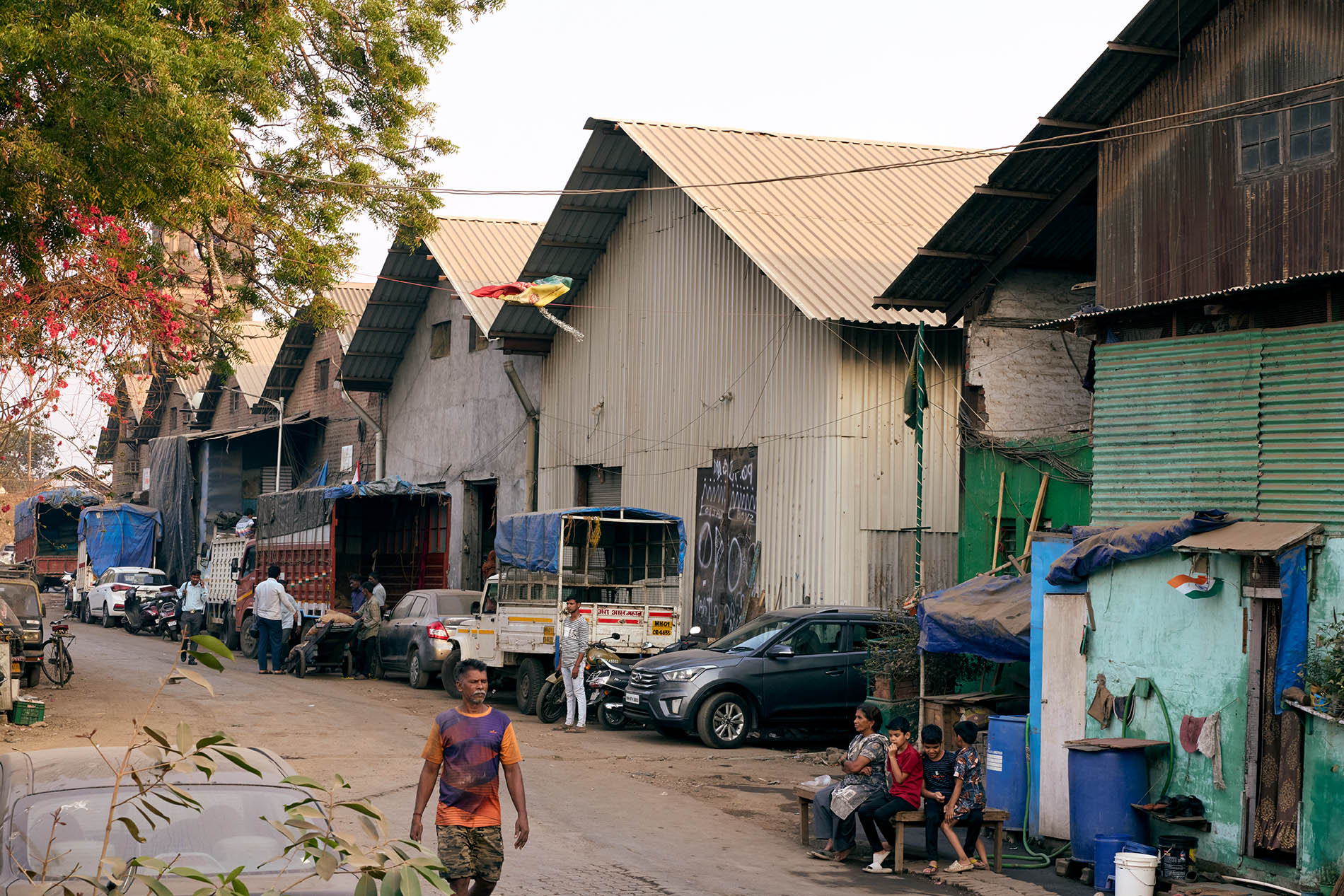 A row of warehouses with people sitting in front of them