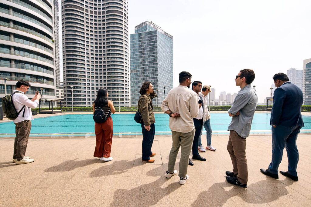 A group of people standing at a swimming pool in a modern housing complex in Mumbai India