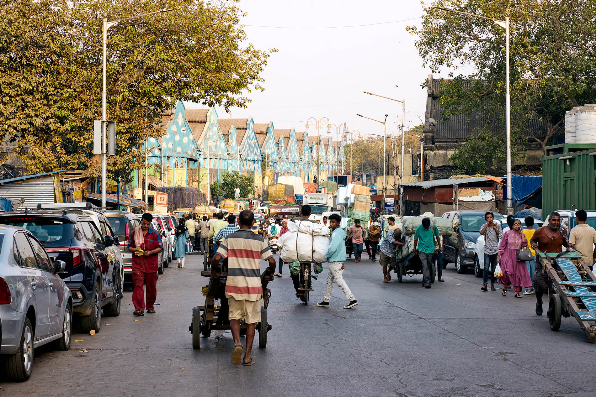 Crowded street with blue warehouses in the background in India