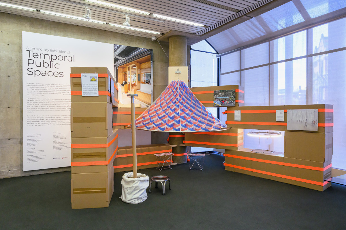A seating area inside an alcove constructed of cardboard boxes and ratchet straps.