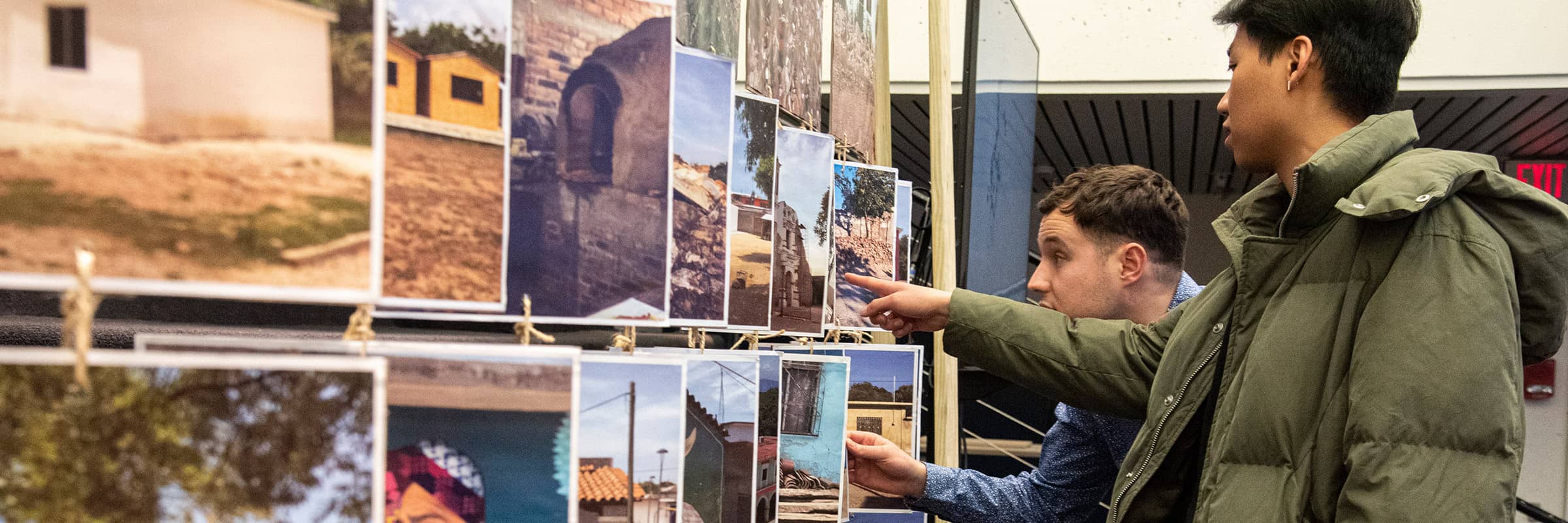 Students looking at photos hung in an exhibition.