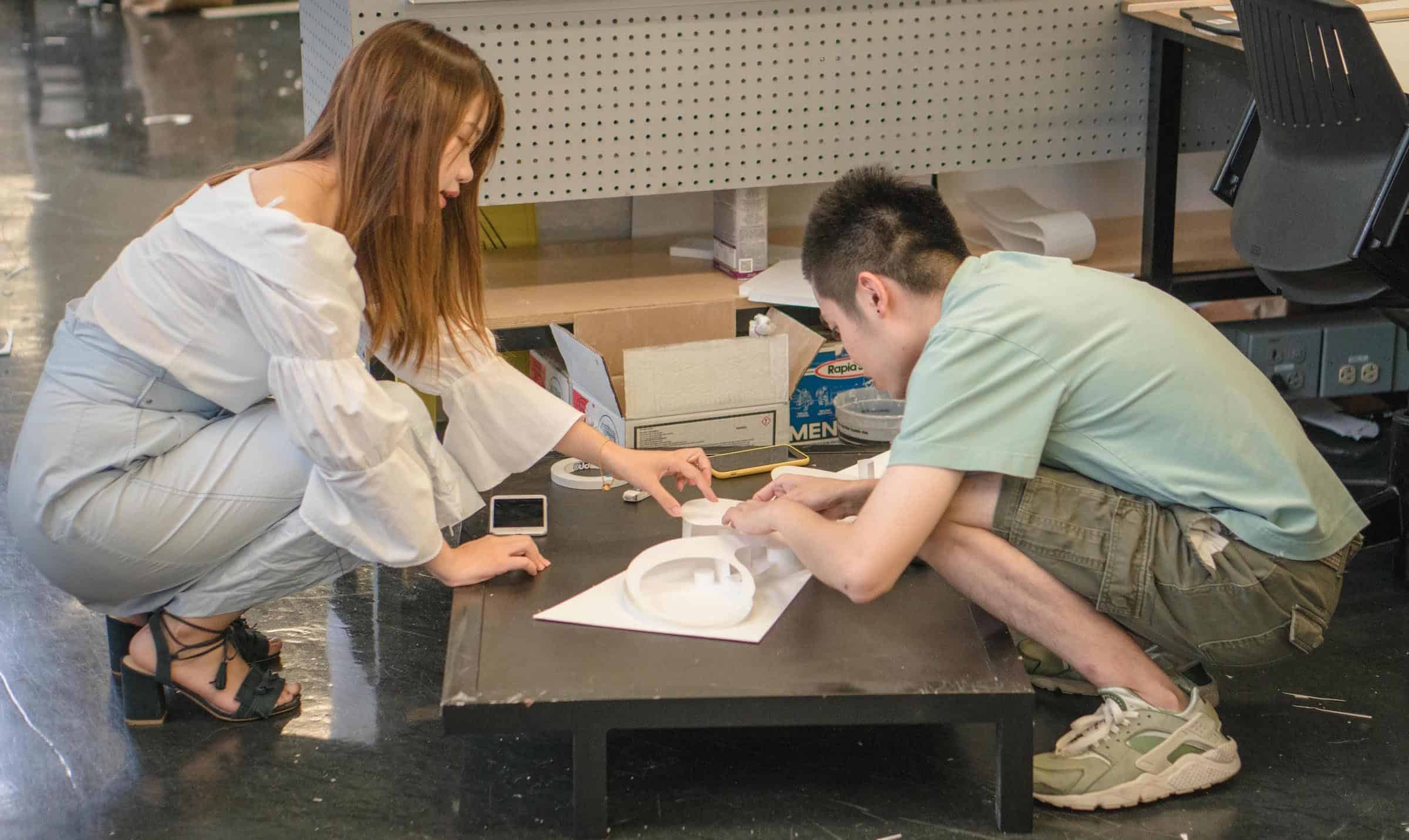 Two Design Discovery students work on a model together.