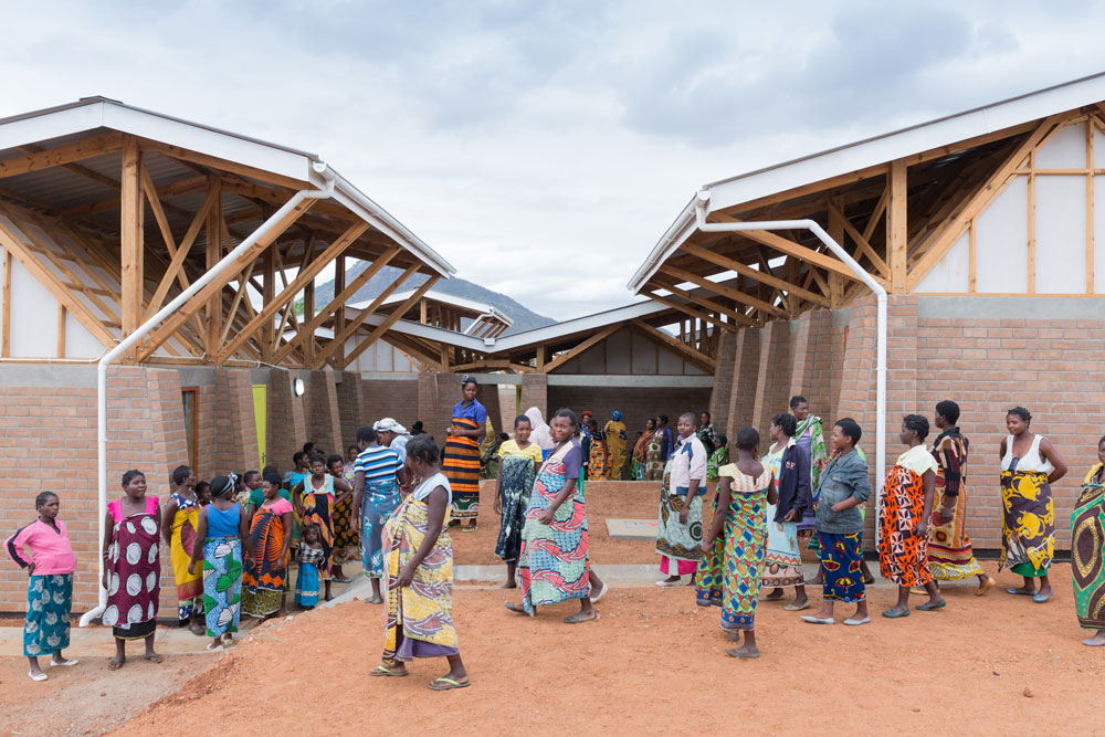 Two dozen women standing in a courtyard.