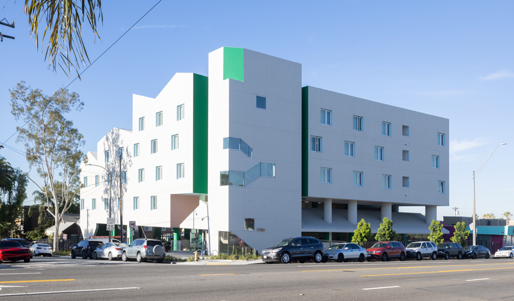 White five-story apartment building with bright teal accents.