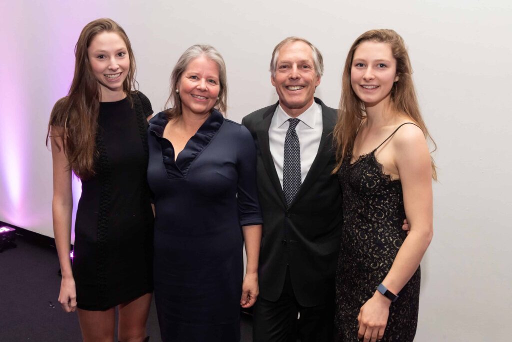 Four people standing and smiling