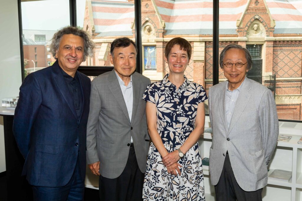 Four people stand posed in front of a window, including Mohsen Mostafavi, Dean Sarah Whiting, and representatives from Takenaka