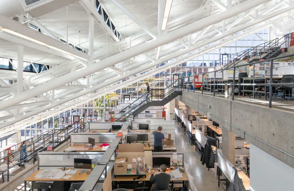 View inside building with glass walls and many design desks.