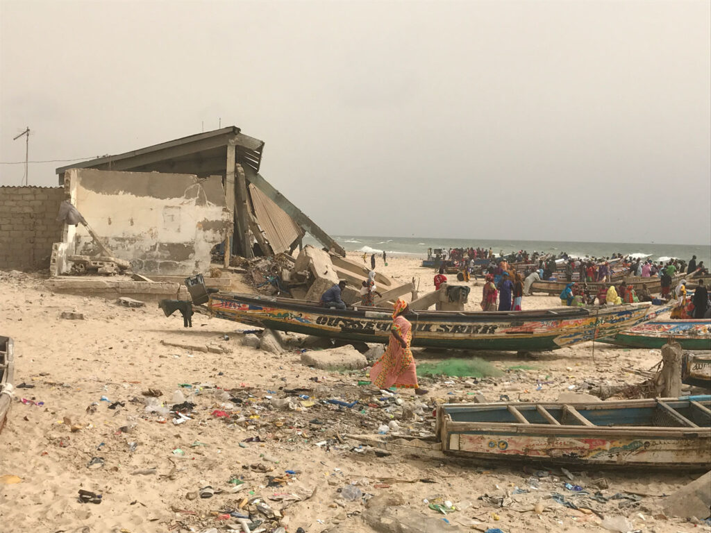 Coastal Erosion zone with debris and boat strewn about.