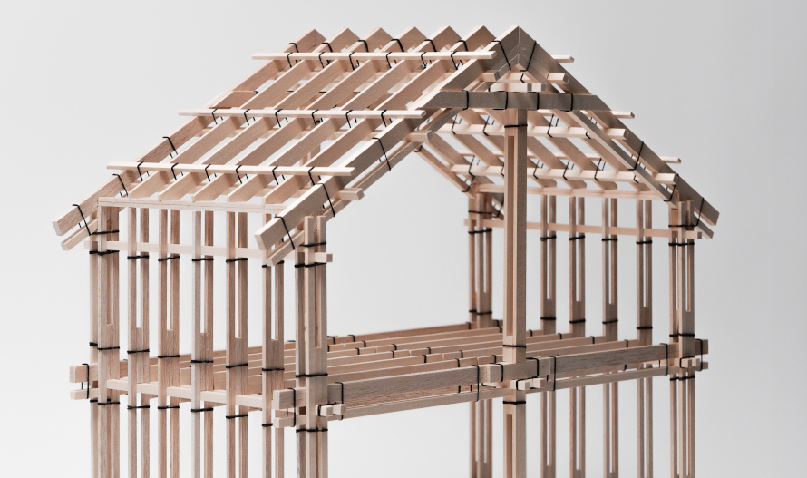 Architectural model of a house-shaped structure built with slats of wood joined to each other with straps.
