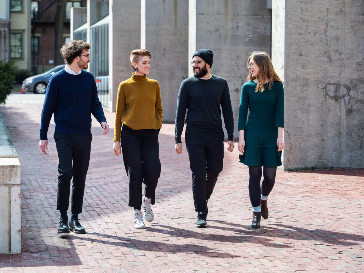 Four students walking near Gund Hall