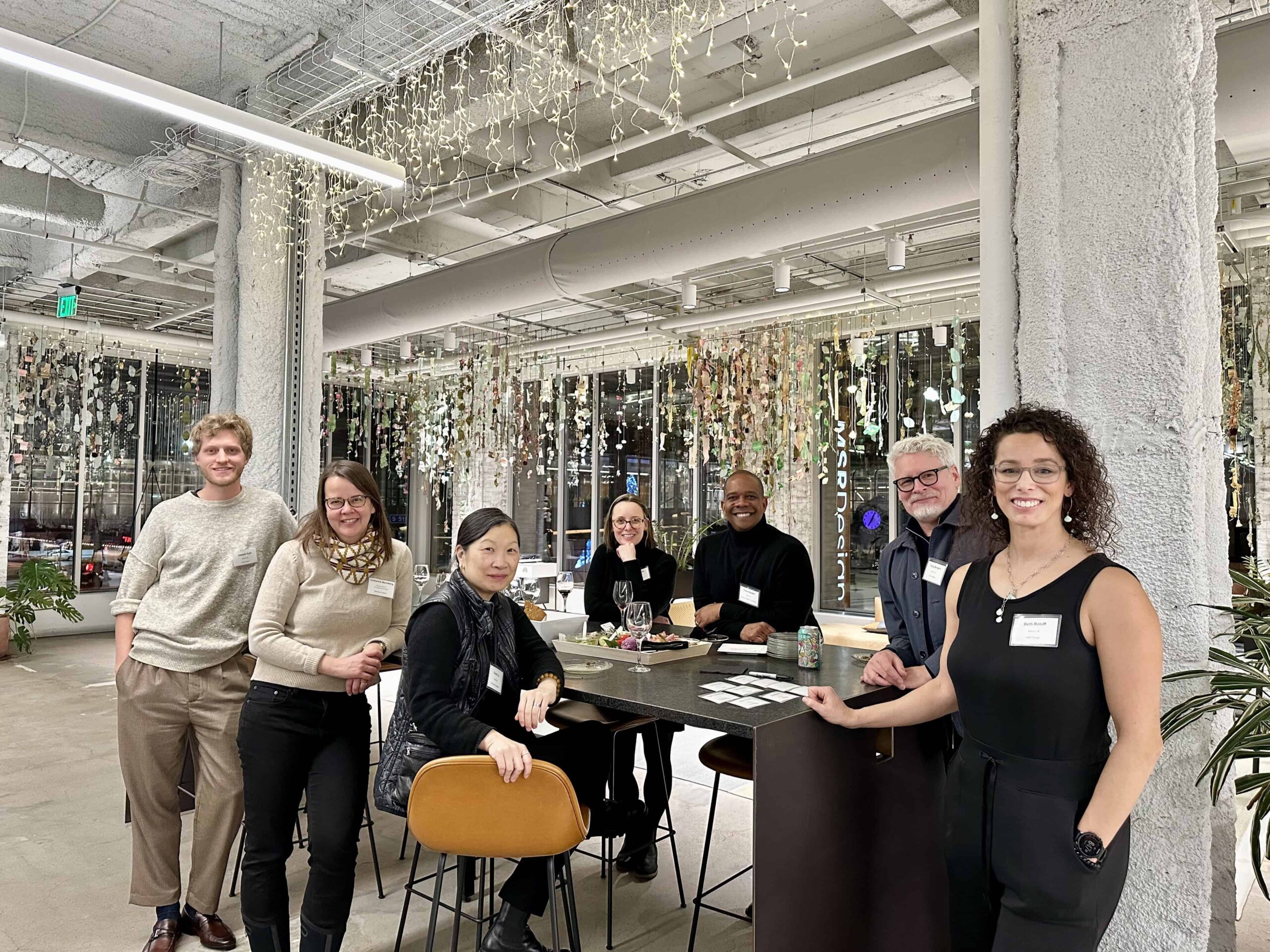 GSD Alumni smile next to a table with appetizers