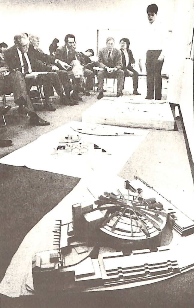 student stands behind model during a studio review in 1987