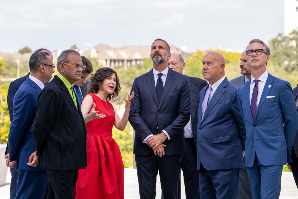 Four men and one woman talk outside.