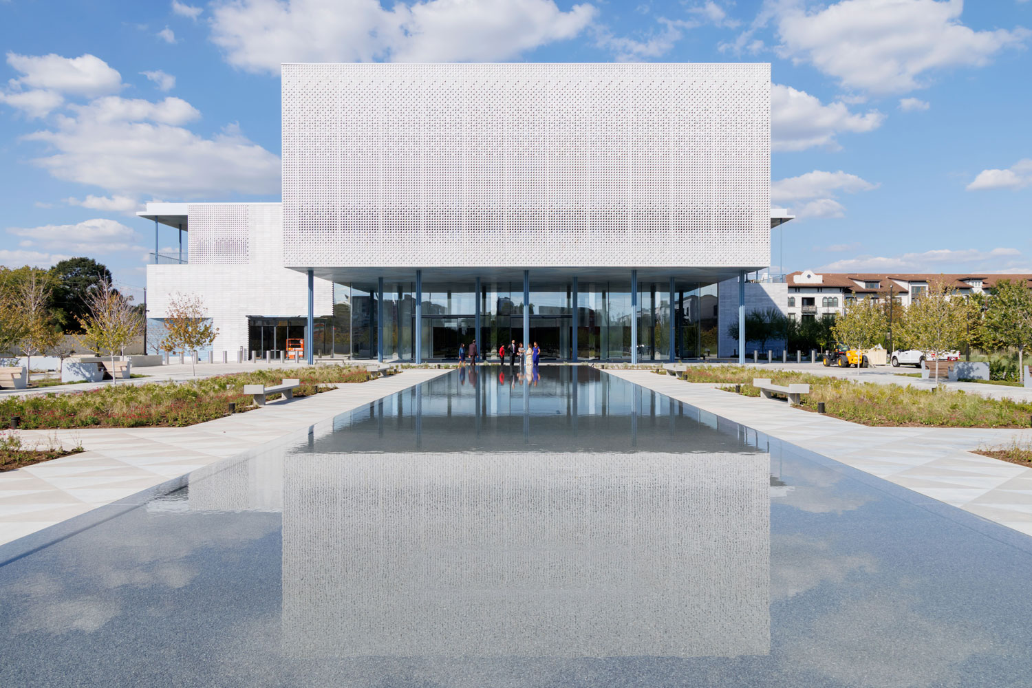 White rectangular building reflected in shallow pool of water.