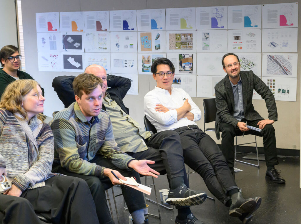 People sit on a review in front of colorful drawings.