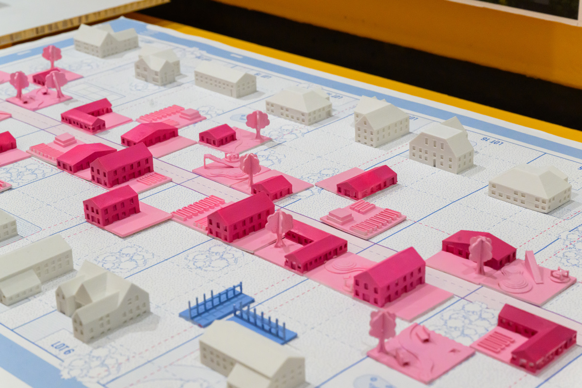 Detail of an architectural model of a group of pink buildings.